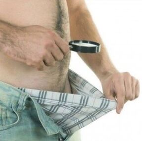 A man looks down at his pants and wants to use gel to enlarge his penis